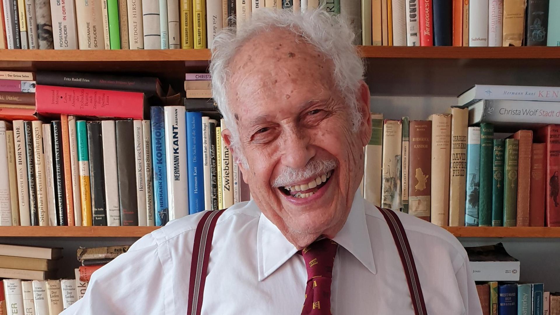 Victor Grossman in front of a bookshelf